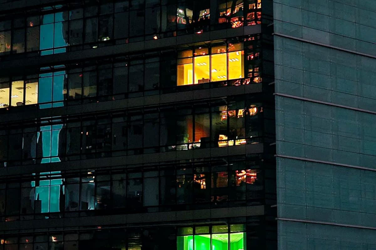 Facility exterior at night with occupied floors lit