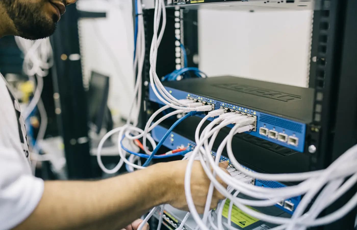 Engineer cabling a switch during a rack build